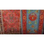 A small Eastern wool rug with central red ground interspersed with floral decoration set within a
