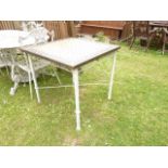 A painted steel framed garden table with square inset mosaic type top, raised on four tubular