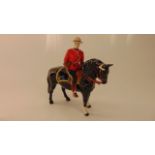 A Beswick equestrian figure of a Canadian Mountie on a black and white horse with white printed mark