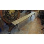An oak bench, raised on four stick supports, 205 cm