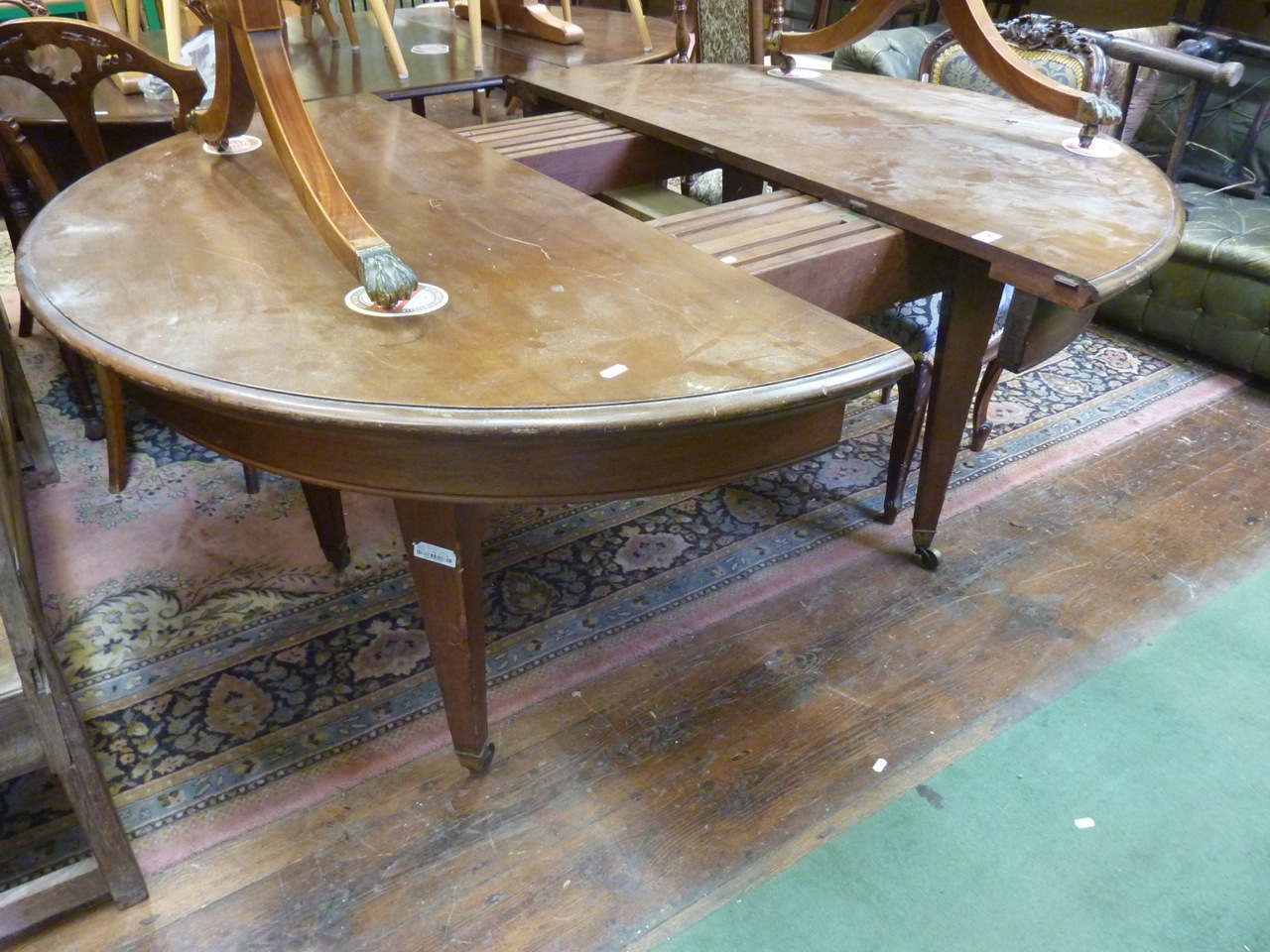 An extending Victorian mahogany D-end dining table raised on four square tapered legs, 130cm wide (