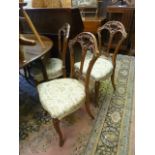 A set of four Victorian walnut dining chairs, the backs with well presented c-scroll, floral and