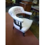 An Edwardian tub chair, the horseshoe shaped back raised on turned supports with upholstered seat