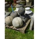 A pair of weathered cast composition stone spheres together with two others of varying size and