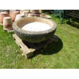 A large weathered composition stone garden urn of squat circular form with domino/disc banded frieze