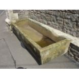 A substantial natural stone trough of rectangular form with notched channels, 200cm long, 73cm wide,