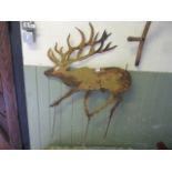 A weathered cut sheet metal garden ornament in the form of a reindeer