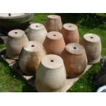 A quantity of contemporary terracotta garden planters of circular tapered form