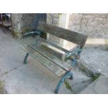 A 2-seat garden bench with weathered hardwood slatted seat and back rail, raised on heavy