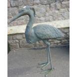 A contemporary weathered hollow cast bronze garden ornament in the form of a heron