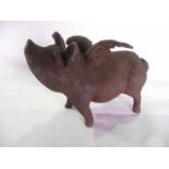 A large cast iron savings bank in the form of a winged pig, standing, with coin slot to the