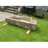 A large weathered natural stone trough of rectangular form with a single canted corner, 142cm