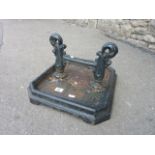 A 19th century cast iron boot scraper with scrolled acanthus detail and rectangular tray base with