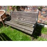 A 2/3 seat garden bench with weathered timber slatted seat and combined back, raised on a pair of