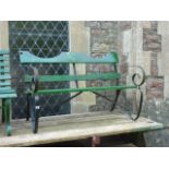 A 2-seat garden bench with timber slatted seat and shaped back rail, raised on sprung steel