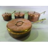 A set of four copper and tin lined saucepans of graduated size with brass handles (complete with