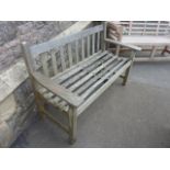 A weathered teak 2-seat garden bench with slatted seat and back, 4ft long approximately