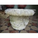 A 19th century carved limestone garden urn with trailing floral detail