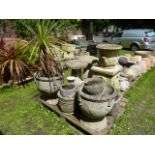 A pair of weathered cast composition stone garden urns of circular tapered form with raised relief