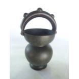 An unusual eastern beaten and raised bronze vessel of gourd form with circular foot and spherical