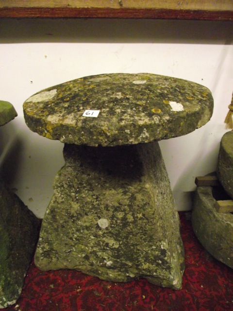 A weathered natural stone staddle stone of tapered form with domed cap