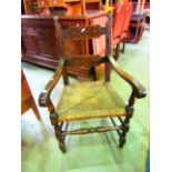 An old English style oak twin bar back open elbow chair with applied split mouldings and carved