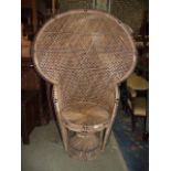 A wicker peacock type chair with shaped outline and circular seat