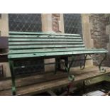 A sprung steel garden bench with wooden slatted seat and combined back and all over green painted