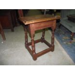 A reproduction old English style oak joint stool with moulded frieze and turned bobbin supports