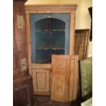 A Georgian stripped pine free standing corner cupboard enclosed by two pairs of rectangular