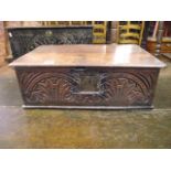 An 18th century oak bible box with hinged lid, the front elevation with carved arcaded foliate