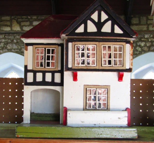 A detailed painted timber 20th century model dolls house with beams in the Tudor style with a hinged