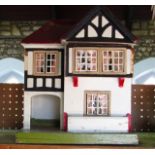 A detailed painted timber 20th century model dolls house with beams in the Tudor style with a hinged