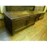 An 18th century oak coffer with hinged lid and panelled frame with moulded and carved detail, 110 cm