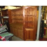 A modern stripped pine kitchen dresser, the base enclosed by three arched panelled doors beneath