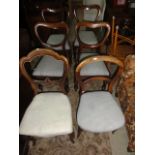 A set of four Victorian mahogany dining chairs with kidney shaped backs over drop-in upholstered