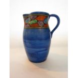 A Blue ground Art Deco jug with painted border decoration and tones of orange, mauve and green in