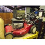 A Sovereign self-propelled petrol rotary lawn mower with Briggs and Stratton engine and grass