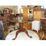 A Georgian style mahogany dining/occasional table, the circular top raised on a turned pillar and