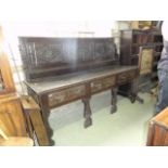 An antique oak dresser, the shallow raised triple rectangular panelled back with carved lozenge