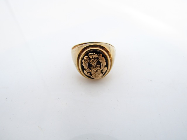 A gentleman's signet ring, the central oval onyx plaque mounted with a gold crest, in 9ct gold, size