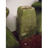 A weathered natural stone staddle stone base of square tapered form