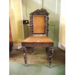 A 19th century Anglo-Indian walnut single chair with profusely carved detail, the cresting rail
