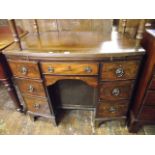 A 19th century mahogany bow fronted desk with brush in slide over an arrangement of seven oak