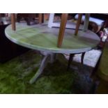 A bleached pine dining table of circular form, the heavy plank top raised on a turned pillar and