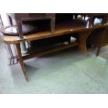 A teak refectory table, the rectangular top with rounded corners raised on a pair of shaped and