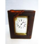 A brass carriage clock with enamel dial and 8 day time piece and case