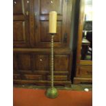 A floor standing heavy brass pricket candlestick with graduated ring stem and domed disc shaped base