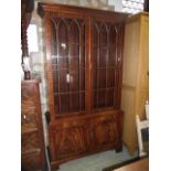 A reproduction mahogany freestanding side cabinet/bookcase in the Georgian style, partially enclosed