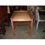 A vintage stripped pine child's school desk with hinged slope and square cut supports